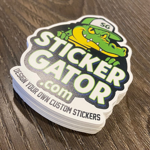 Stack of 'Sticker Gator' stickers on a wooden surface